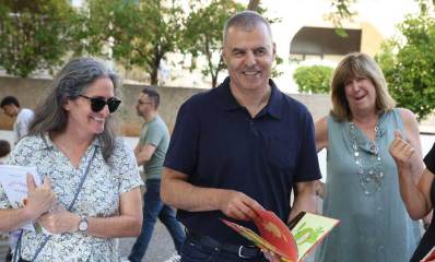 רפי סער בשבוע הספר בעיר ביוני 2026. עם ספר ילדים בידיו ואישה בכל צד שלו.