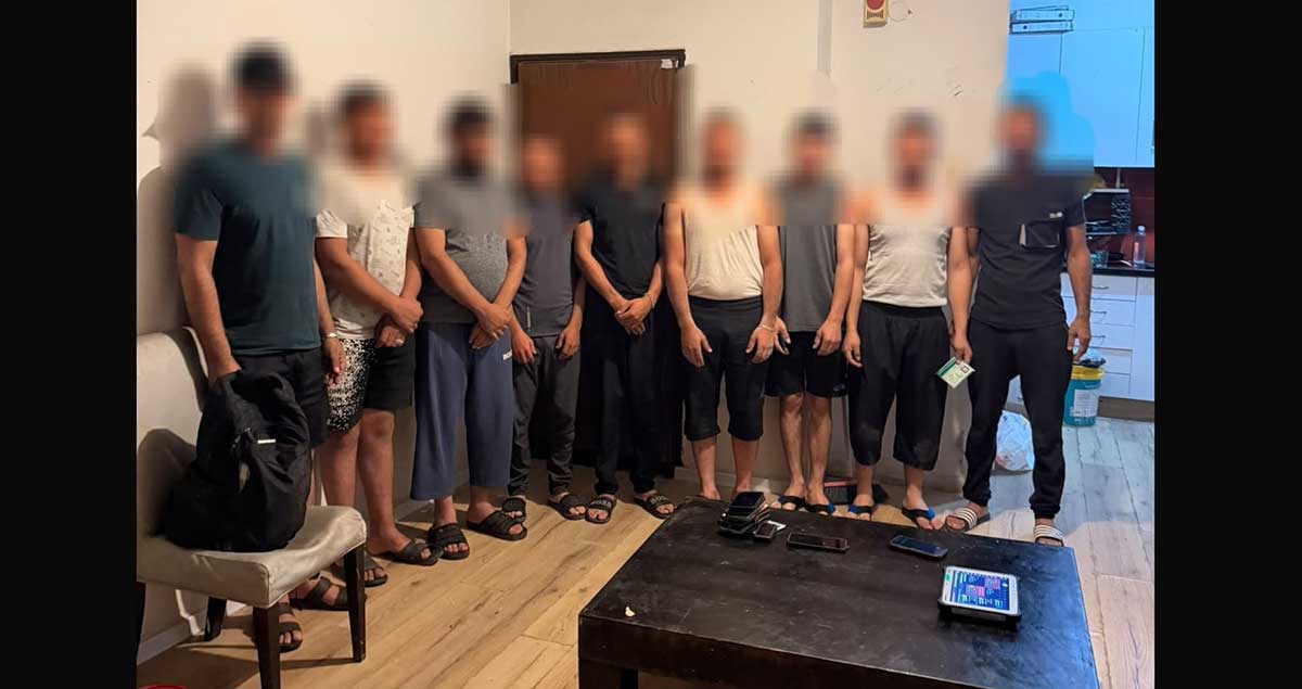 9 שב"חים מהשטחים בדירה במרכז הרצליה. עומדים בשורה ליד דלת הכניסה.