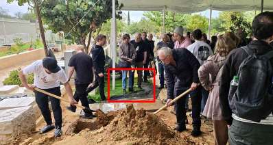 יוסי יהב מעמותת קבורה נכונה ברמת השרון. כיסוי הקבר על ידי שני גברים עם אתים. והקהל מסביב שנוחת בקבורה