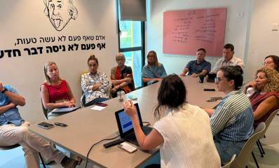 ראש העיר הרצליה, יריב פישר, מקיים ישיבות במרכז נינא. המשתתפים יושבים סביב שולחן ארוך. על הקיר תמונה של איינשטיין וכיתוב: אדם שאף פעם לא עשה טעות, אף פעם לא ניסה דבר חדש