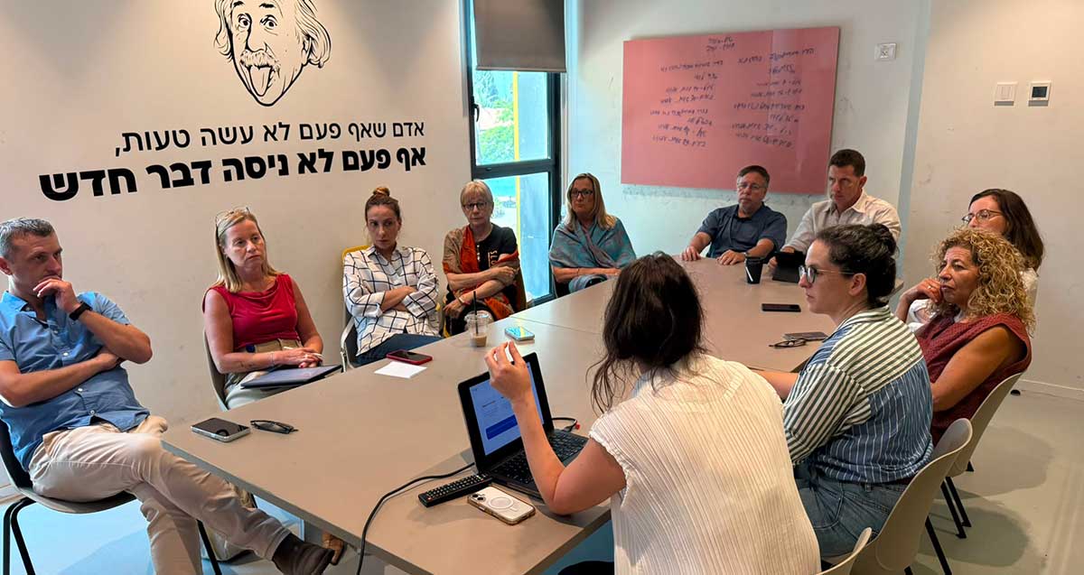 ראש העיר הרצליה, יריב פישר, מקיים ישיבות במרכז נינא. המשתתפים יושבים סביב שולחן ארוך. על הקיר תמונה של איינשטיין וכיתוב: אדם שאף פעם לא עשה טעות, אף פעם לא ניסה דבר חדש