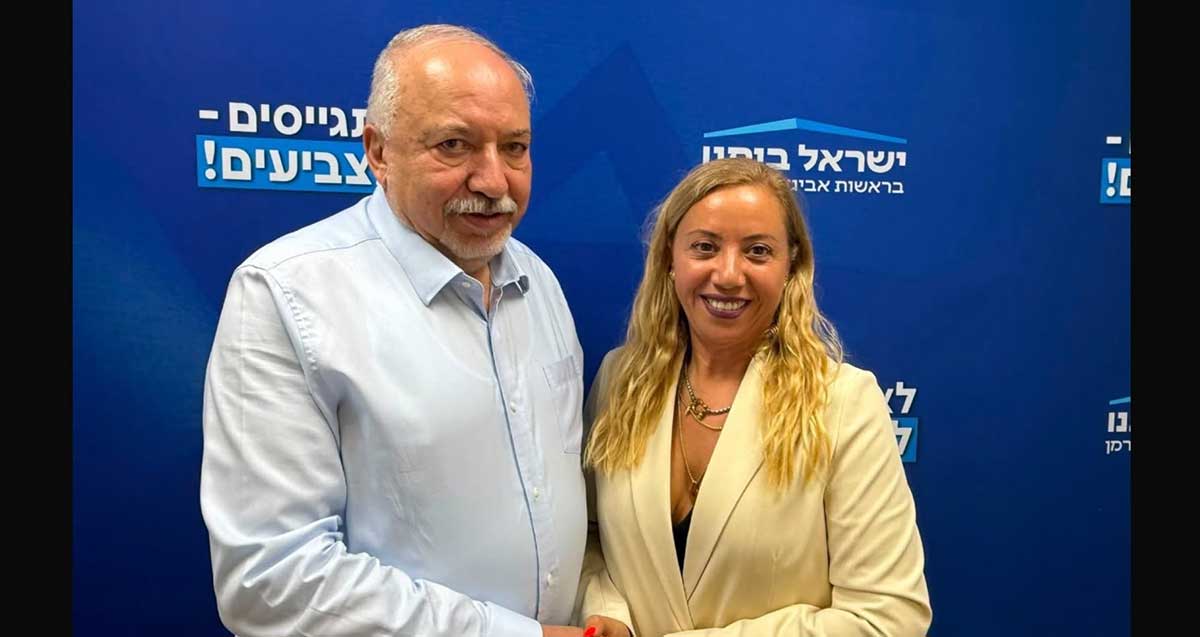 ענבר סמובסקי עם אביגדור ליברמן. מאחוריהם על קיר כיתוב: ישראל ביתנו, לא מתגייסים - לא מצביעים!