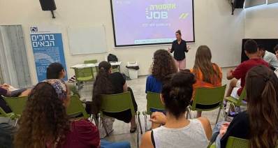מיזם ג'ובים לבני נוער. בני נוער יושבים באולם מול מדריכה ומסך עליו הכיתוב: אקסטרה JOBS מיזם תעסוקה לנוער בקיץ