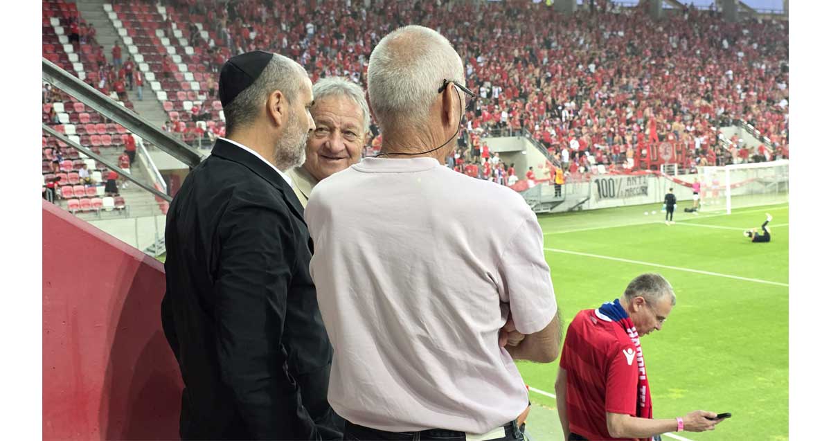 משמאל - יעקב קורצקי, שייע פייגנבוים, יעקב אקהויז, יריב לוין. עומדים ביציע של אצטדיון כדורגל.