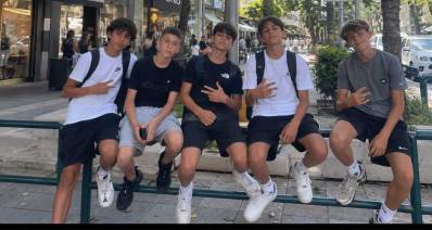 חבורת נערים. איור AI. חמישה צעירים יושבים על הברזלים במדרכה.