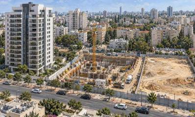 אתר בנייה באזור אורבני. איור AI. שני מתחמים, אחד בשלבי בנייה והשני משטח חול.