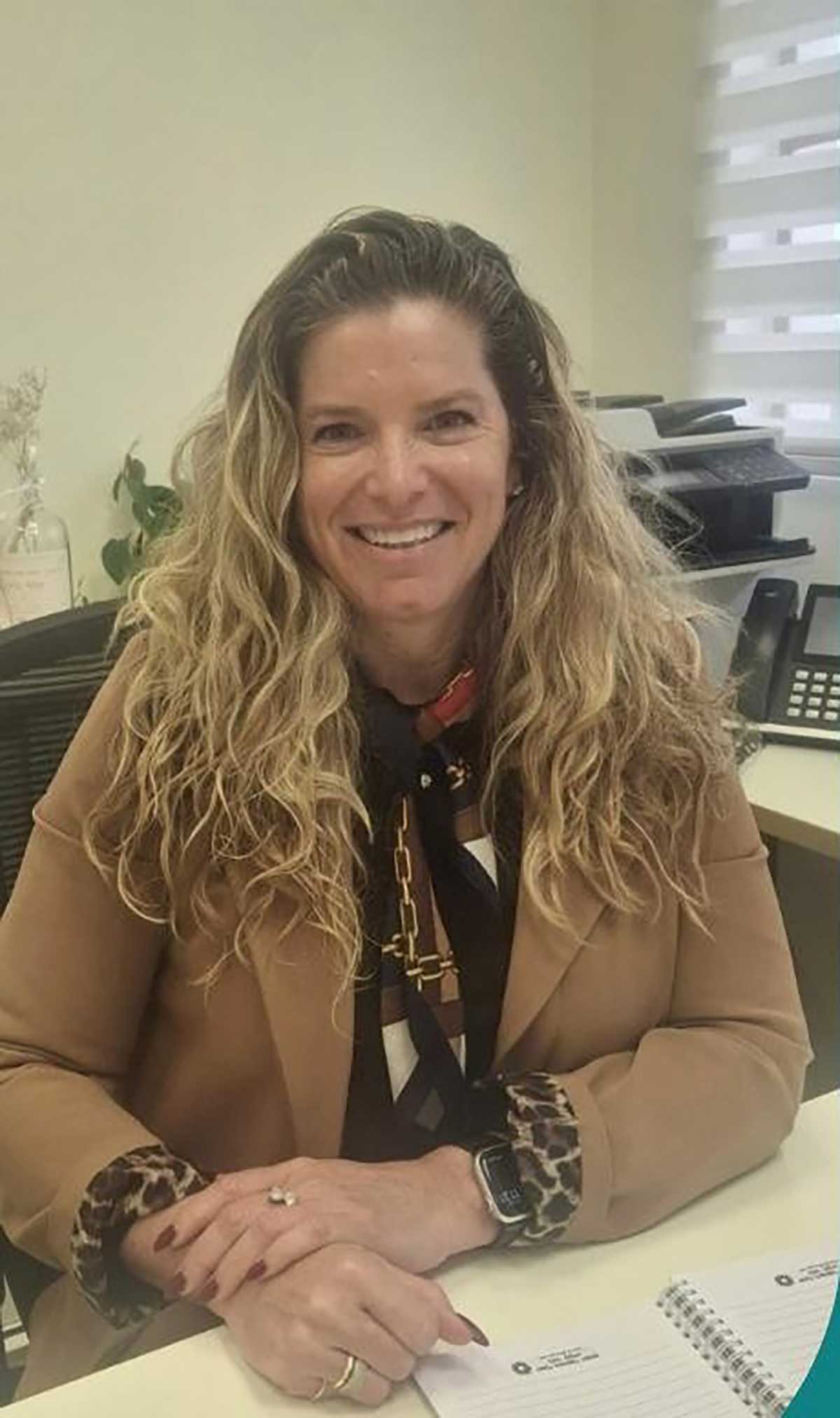 ענבל ברימר משיח ראשת מינהל החינוך. יושבת ליד שולחן במשרד.