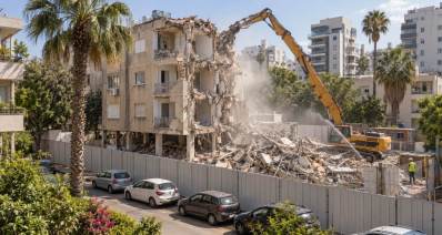 איור של אתר פינוי בינוי עם מחפר הורס בניין מגורים ישן בשכונה עירונית. שרון אונליין