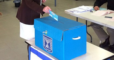 מעטפת הצבעה מוכנסת לתיבת קלפי כחולה, צילום ארכיון