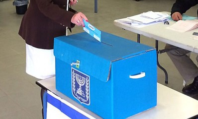 מעטפת הצבעה מוכנסת לתיבת קלפי כחולה, צילום ארכיון