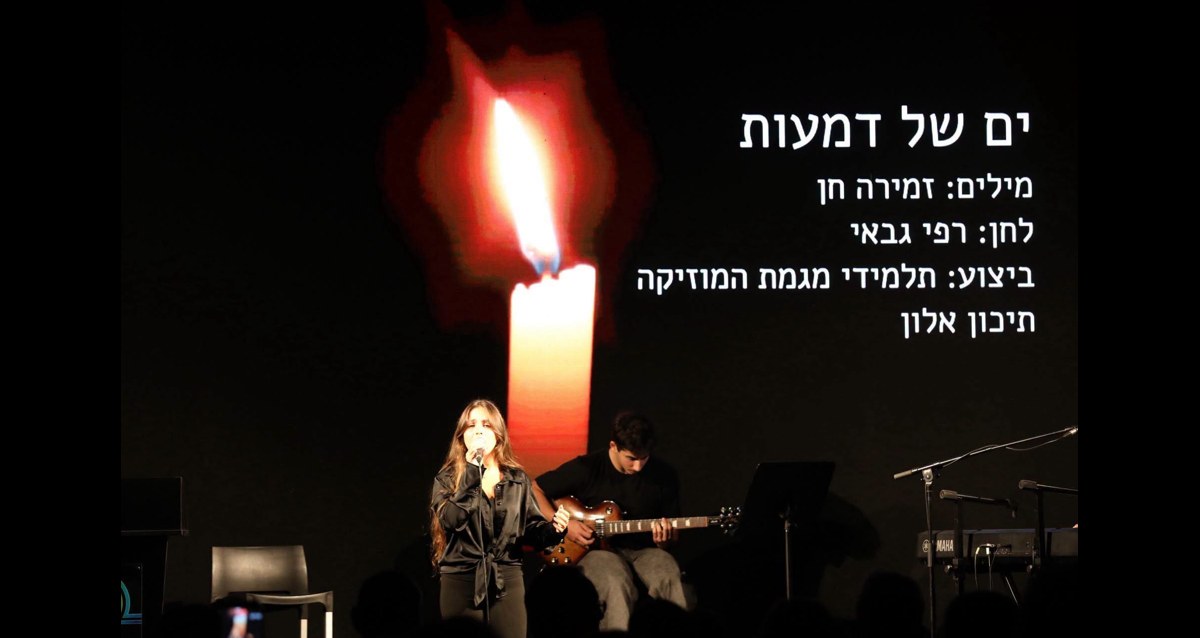 תלמידי תיכון אלון בביצוע ים של דמעות על רקע נר זיכרון